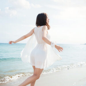 海辺を走る女性の後ろ姿